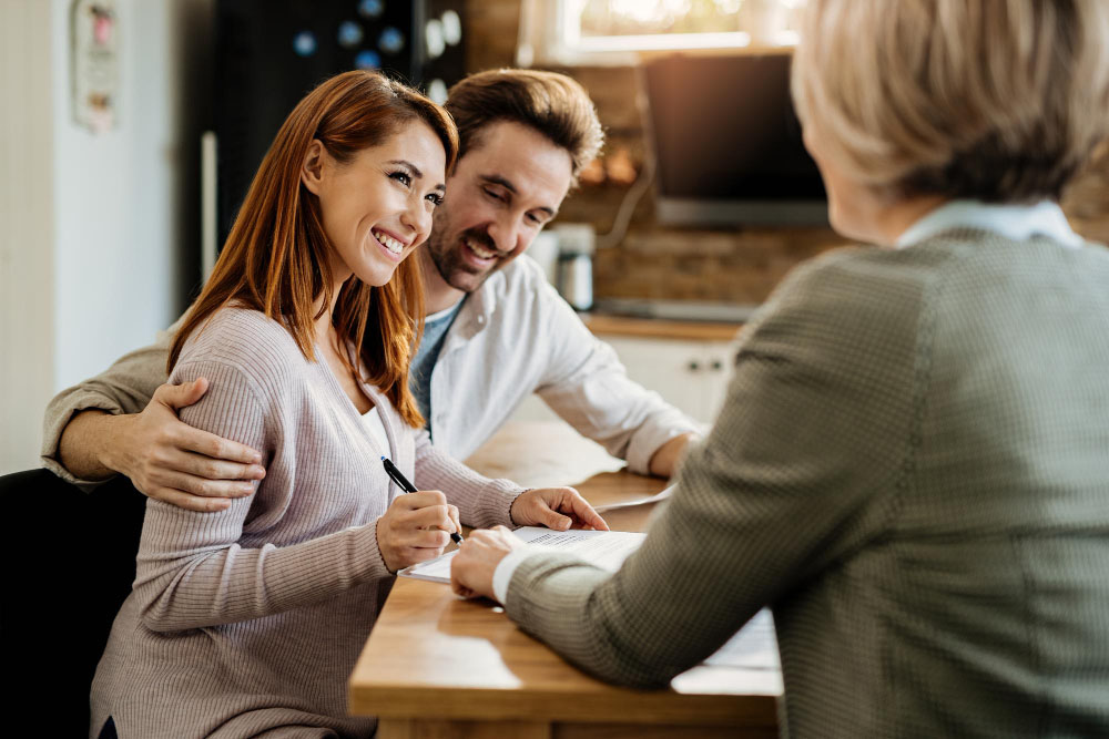 young-happy-woman-her-husband-signing-agreement-with-insurance-agent-during-meeting1